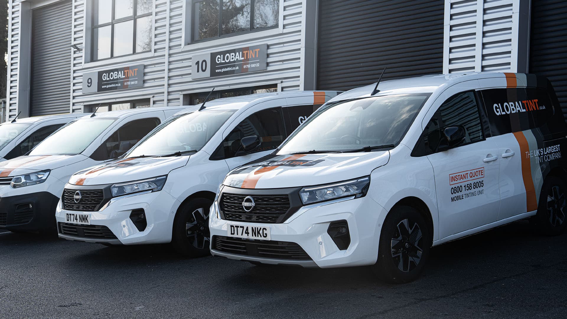 Global Tint’s branded mobile tinting vans outside its headquarters