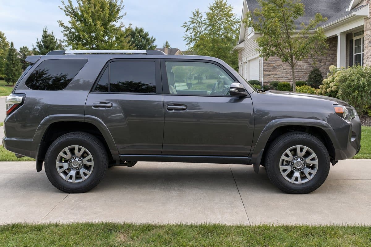 A graphite grey Toyota 4Runner on a driveway, its windows half clear and half tinted