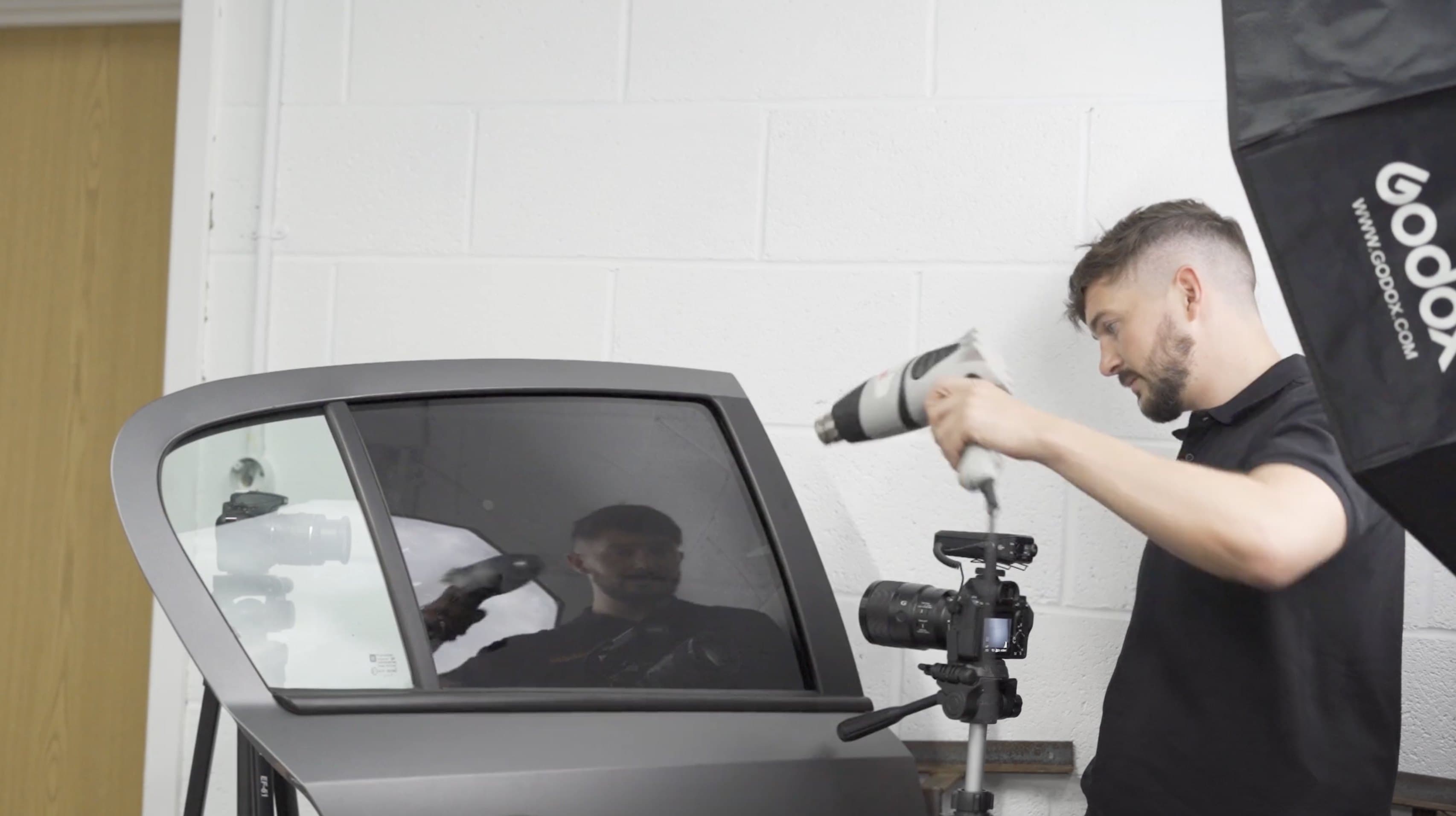 Elliot filming a close-up window tinting demonstration in the TSO studio